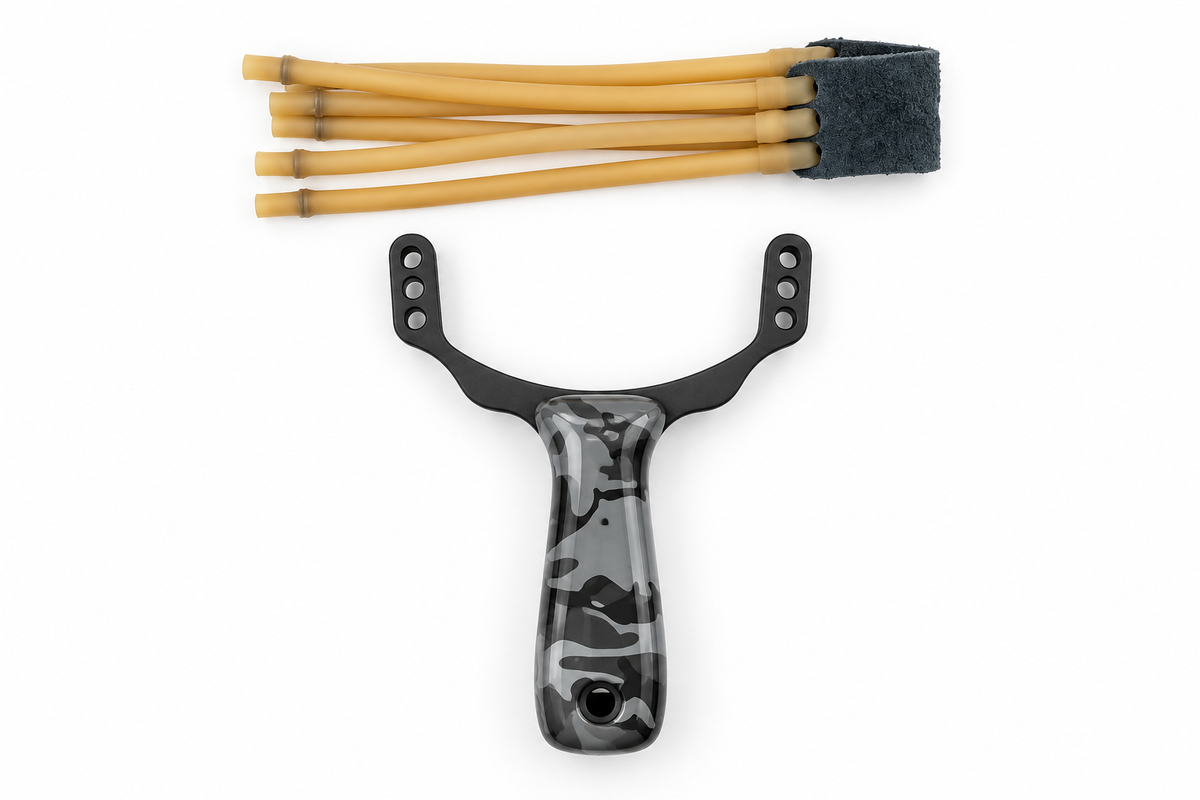Resortera táctica de precisión con mango ergonómico camuflaje negro y gris, horquilla metálica negra perforada y bandas de látex tostado con bolsa central gris oscuro, vista superior desarmada